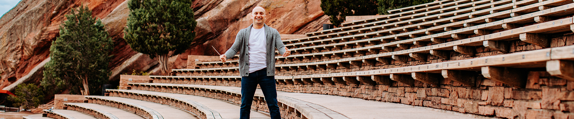 conductor waiving baton while standing at Red Rocks